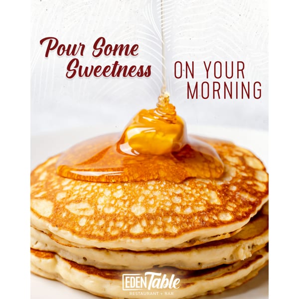 Golden syrup pouring over a stack of fluffy pancakes from Eden Table Restaurant + Bar.