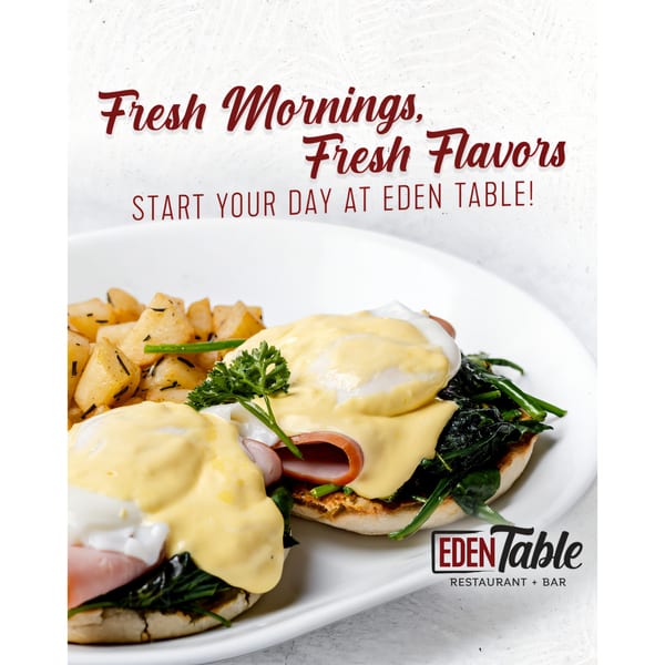Eggs Benedict with ham, spinach, and hollandaise sauce, served with roasted potatoes.